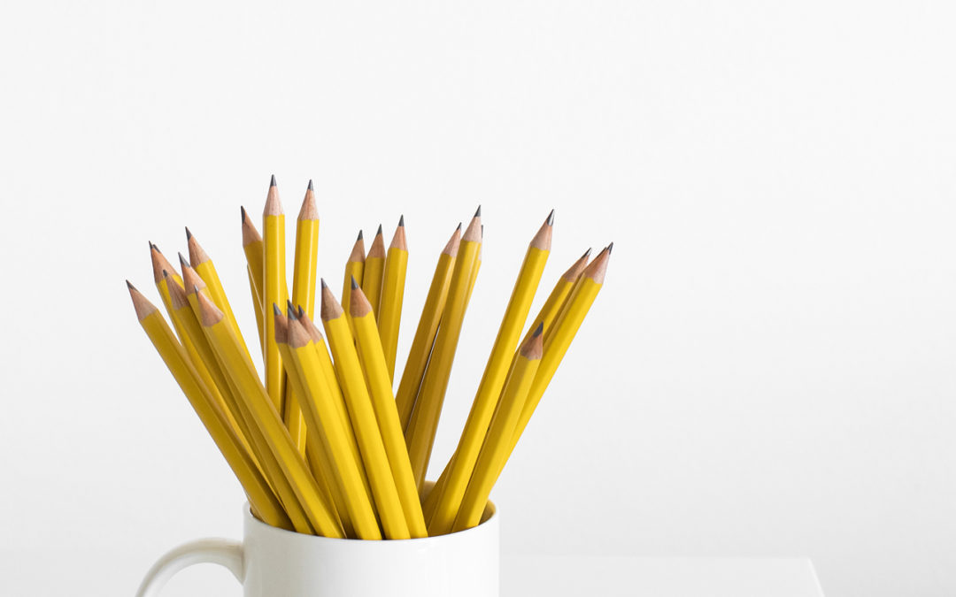 A white coffee mug with yellow #2 pencils in it